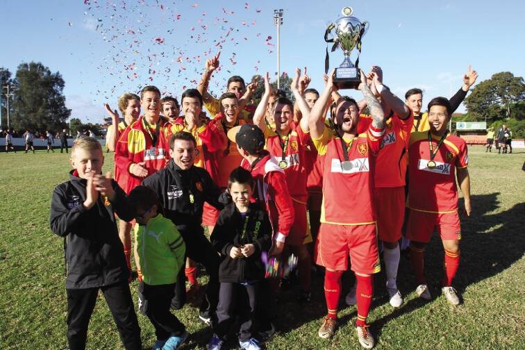Wollongong United players and supporters celebrate winning the Bert Bampton Cup.