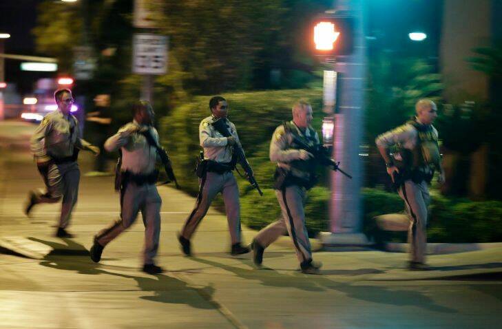 Police run to cover at the scene of a shooting near the Mandalay Bay resort and casino on the Las Vegas Strip. Picture: AP