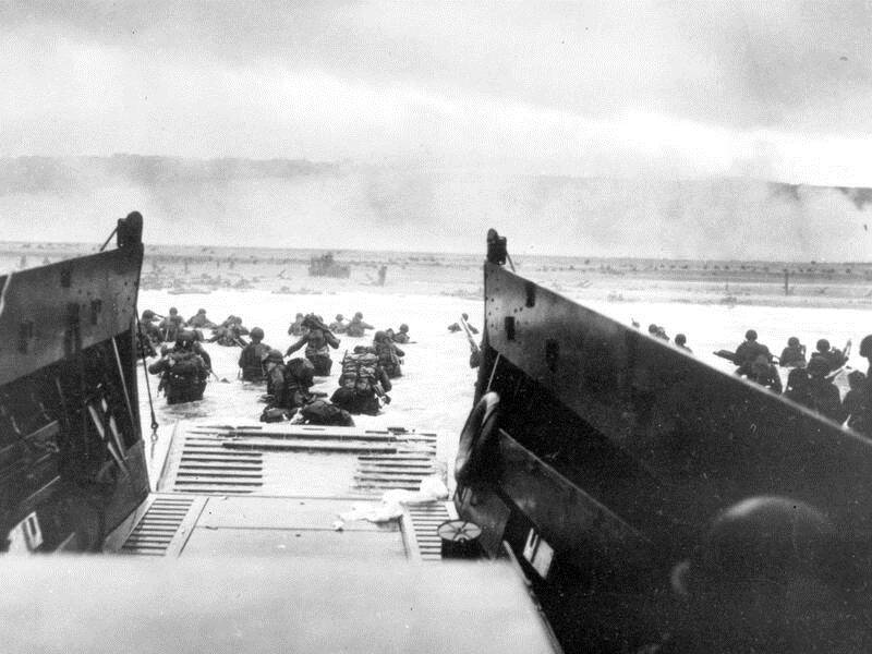 US troops wade ashore off the ramp of a landing craft during the invasion of Normandy in June, 1944.