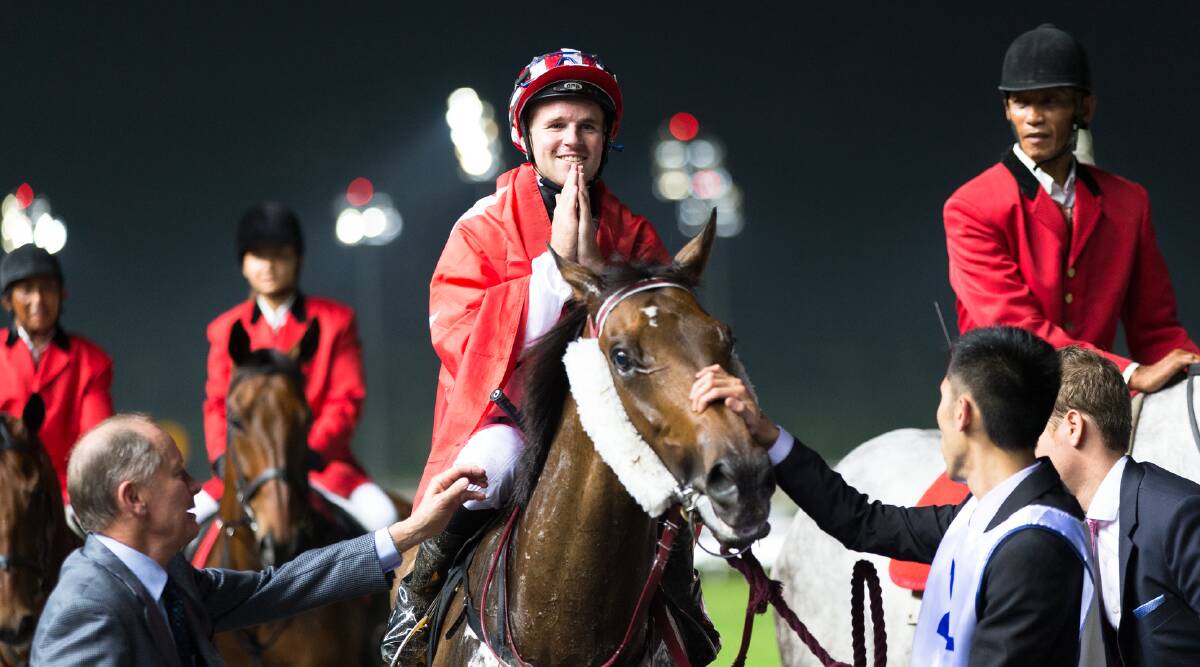 Tommy Berry is met by John Moore after winning the International Cup in Singapore. Picture: GETTY IMAGES