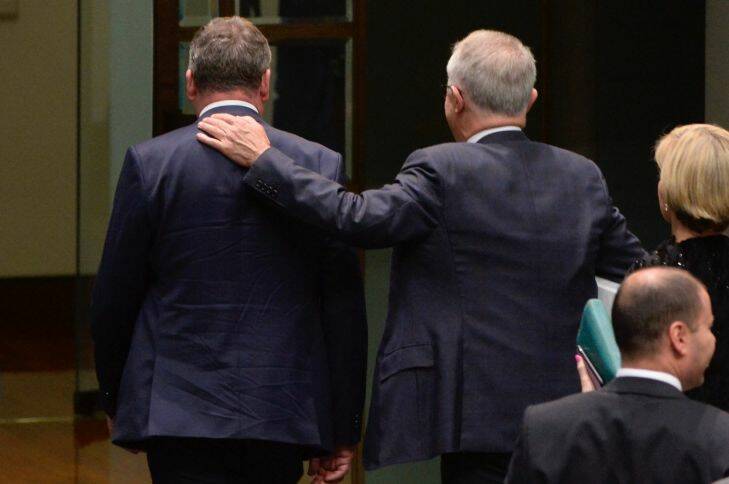 Malcolm Turnbull with his arm on Barnaby Joyce shoulder after narrowly avoiding defeat on the floor of house of reps fedpol . Pic Nick Moir 6 dec 2017
