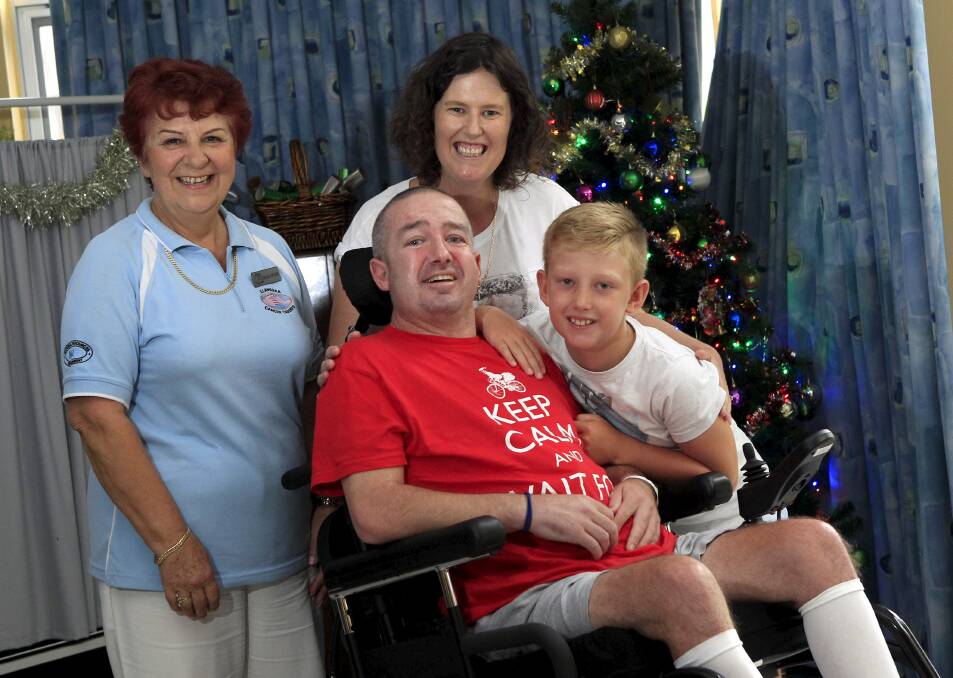 Mobile: Stroke victim Darren "Bud" Gottaas, with Illawarra Cancer Carers' Maria Wilson, wife Karen and son Jed, in his motorised wheelchair, is going home for Christmas. Picture: ANDY ZAKELI