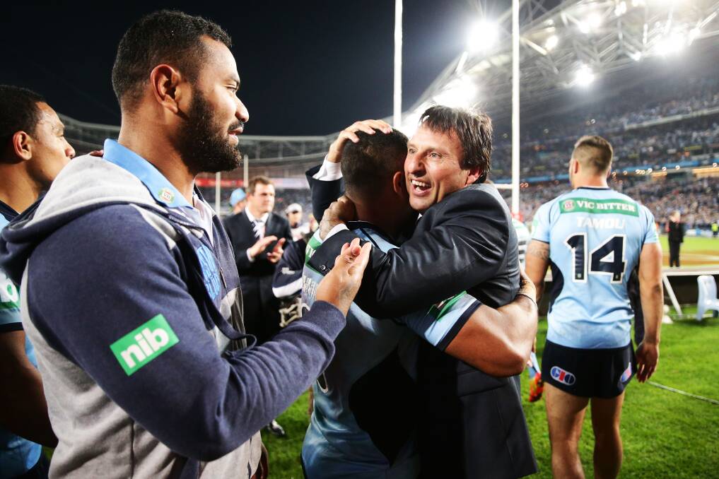Coach Laurie Daley celebrates with his Blues players after New South Wales’ victory in game two at  ANZ Stadium in Sydney. Picture: GETTY IMAGES
