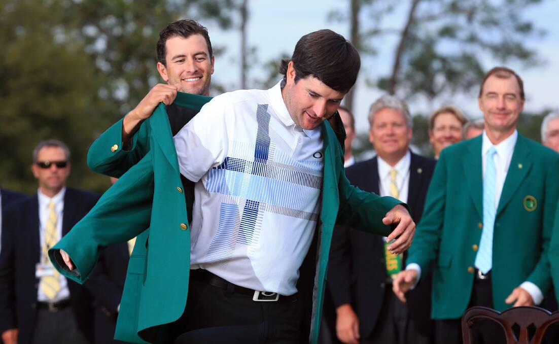 Adam Scott presents Bubba Watson with the green jacket for winning the 2014 Masters. Picture: GETTY IMAGES
