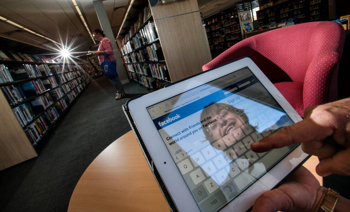 Joanne McIntosh at Warrawong library on an iPad. She has been taking short courses at the library on how to use tablets and social media sites. Picture: ADAM McLEAN