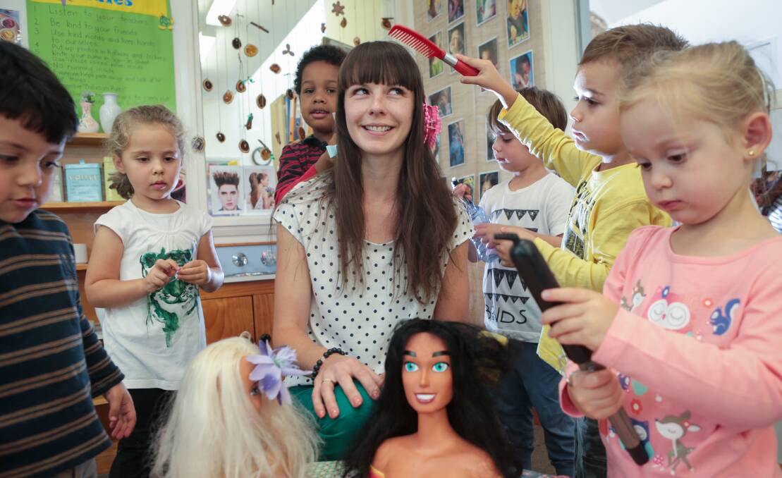 Kids from Short Street Preschool and Occasional Care Centre practise their hairdressing skills on Emma Barrow. Picture: ADAM McLEAN