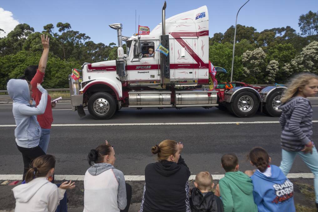 Spectators cheer on the trucks at the bottom of Mt Ousley Road as they make their way to Albion Park during the i98FM Camp Quality Convoy on Sunday. Picture: CHRISTOPHER CHAN 