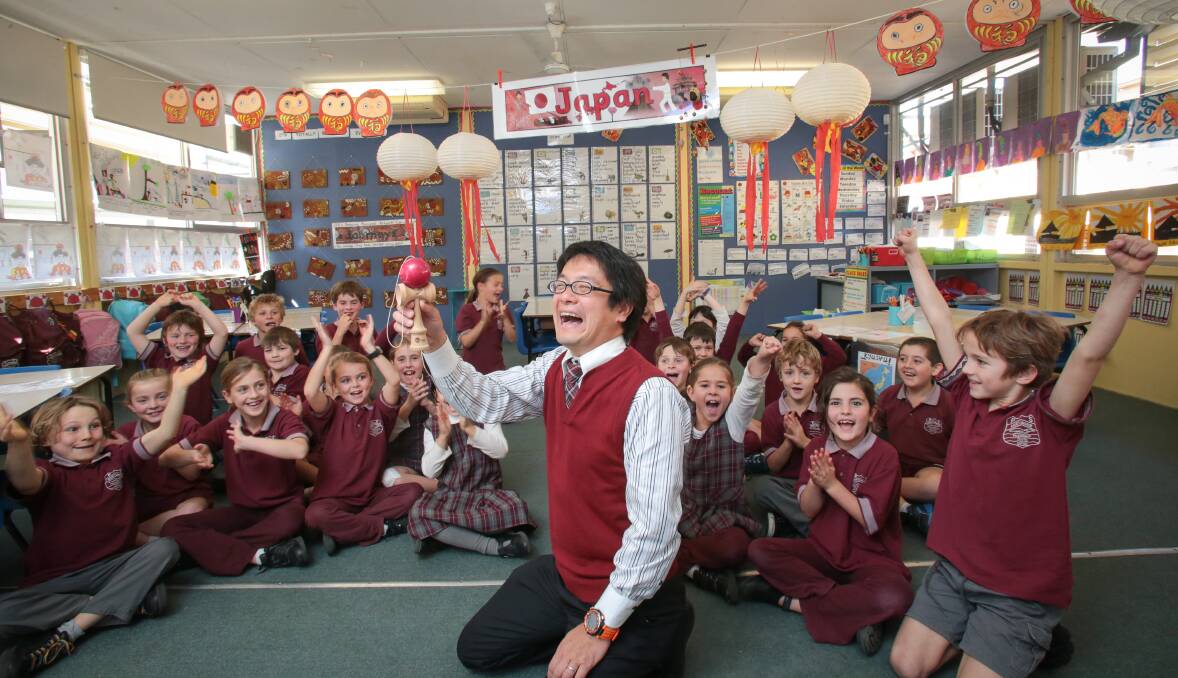 Teacher Yoshiharu Kato shows children how to play a Japanese ball game at Austinmer Public School. Picture: ADAM McLEAN