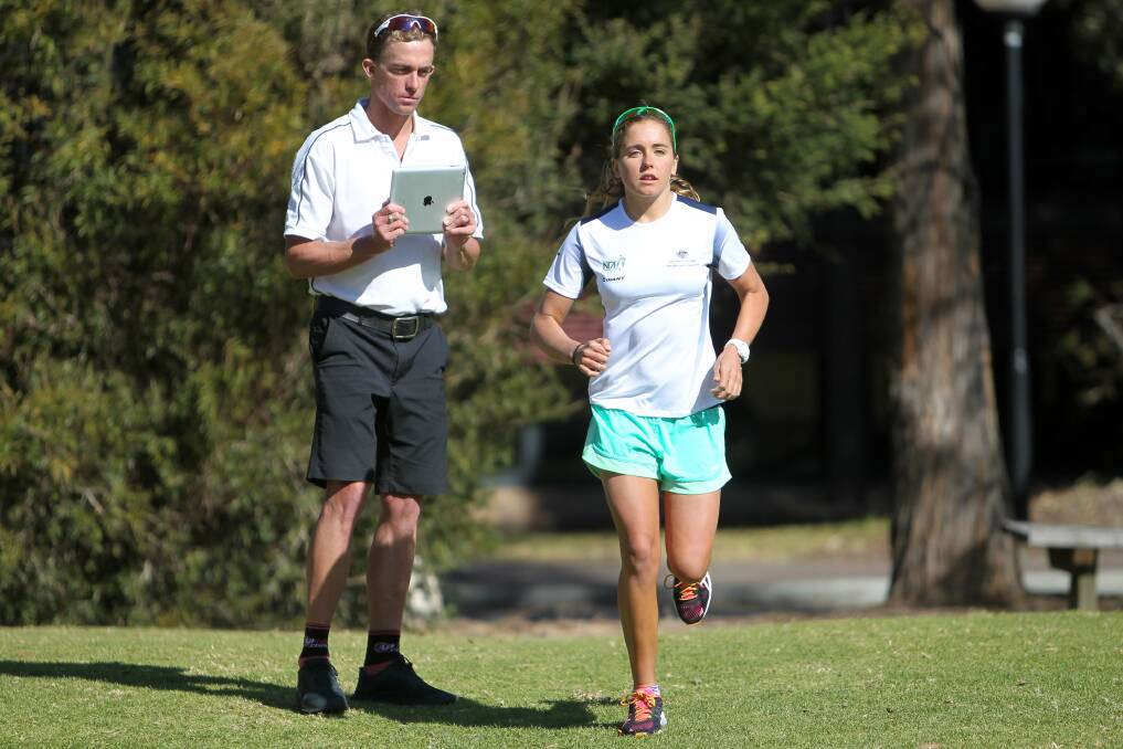 Australian triathlon team physiotherapist Alex Price putting Grace Musgrove through her paces at training this week. Picture: GREG TOTMAN