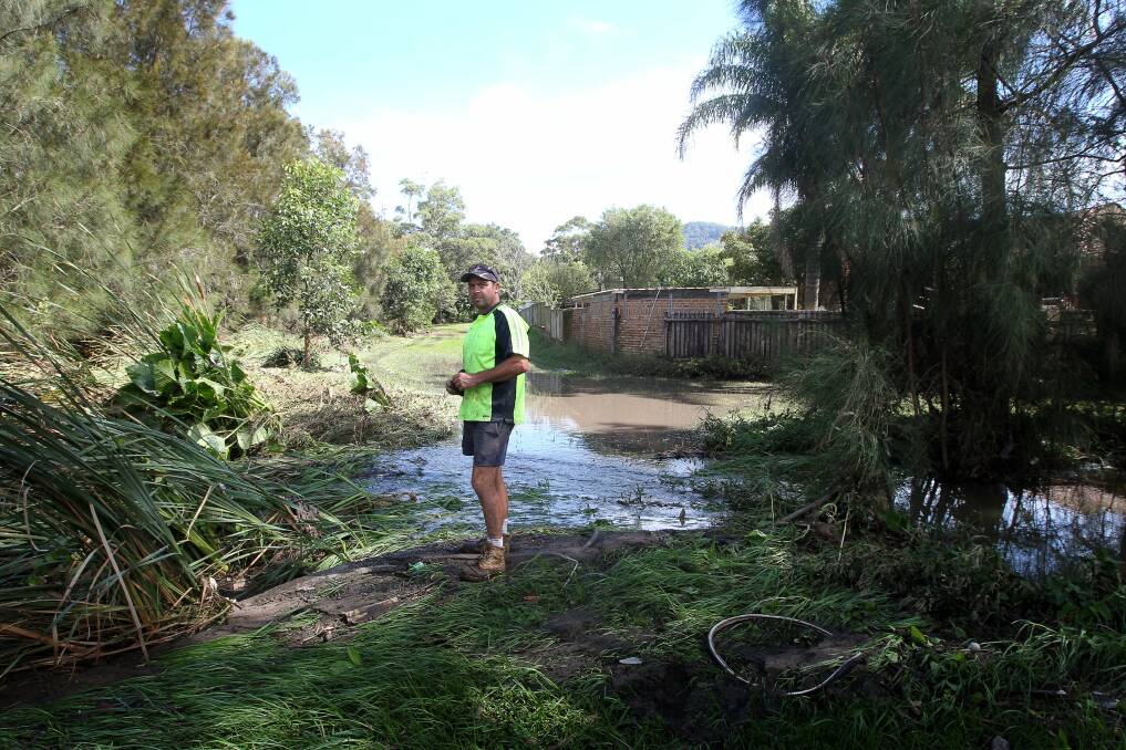 Barry Basham inspects the creek that overflowed on Monday night, sending a flood through his Russell Vale home nearby.  Picture:  SYLVIA LIBER
