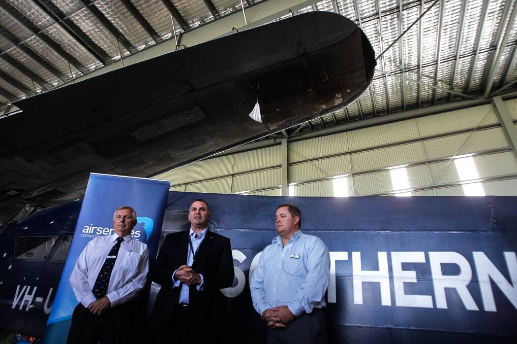 HARS president Bob De La Hunty, AirServices' Rob Walker, and Geoff Timms with the replica of the Southern Cross. Picture: CHRISTOPHER CHAN