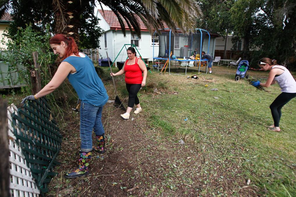 Carol Lee-Carroll, left, is helped by neighbours to fix fencing in her back garden in readiness for the return of the family dog Miss Lilly. Picture: CHRISTOPHER CHAN