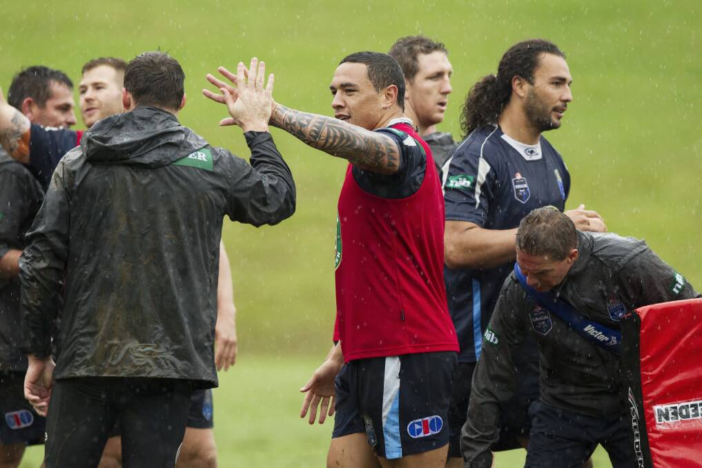 Tyson Frizell, right, high fives a Blues teammate during training. Picture: JAMES BRICKWOOD