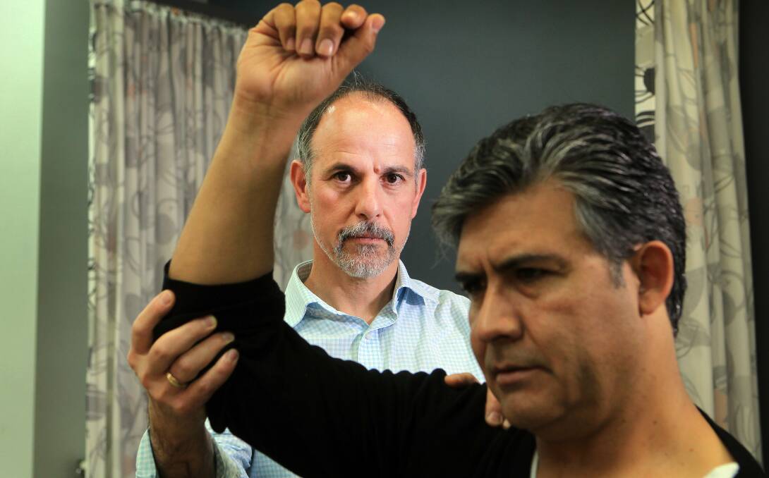 Suffering: Physio Beraldo Lilli with his patient Gonzalo Pena who had to give up his job. Picture: SYLVIA LIBER