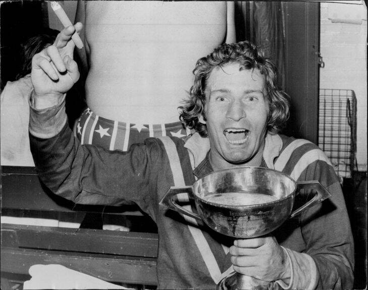 Graeme Langlands, with a cigar in his hand and the Ashes Cup full of champagne in the other, relaxes in the dressing room after leading Australia to their 22-18 win in the third Rugby League Test at the SCG. Langlands, who was playing his final Test, scored a try and kicked five goals to take his points tally in Anglo-Australian Test matches to 104. July 20, 1974. (Photo by John Patrick O'Gready/Fairfax Media).