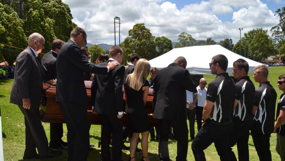 Flanked by Berry Shoalhaven Heads teammates, Blaine Rozs is carried onto the field to be farewelled by hundreds of mourners at Berry Showground on Friday.
