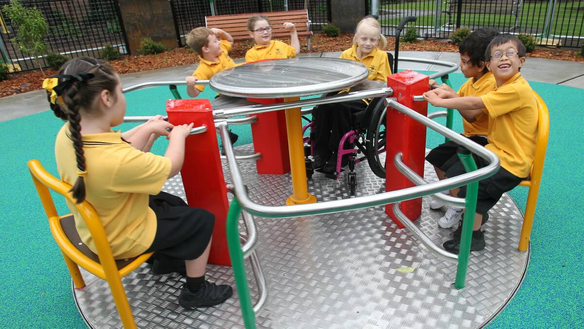 Students try out the newly opened Luke’s Place playground, in Corrimal, which is ideal for children with and without disabilities. Picture: GREG TOTMAN