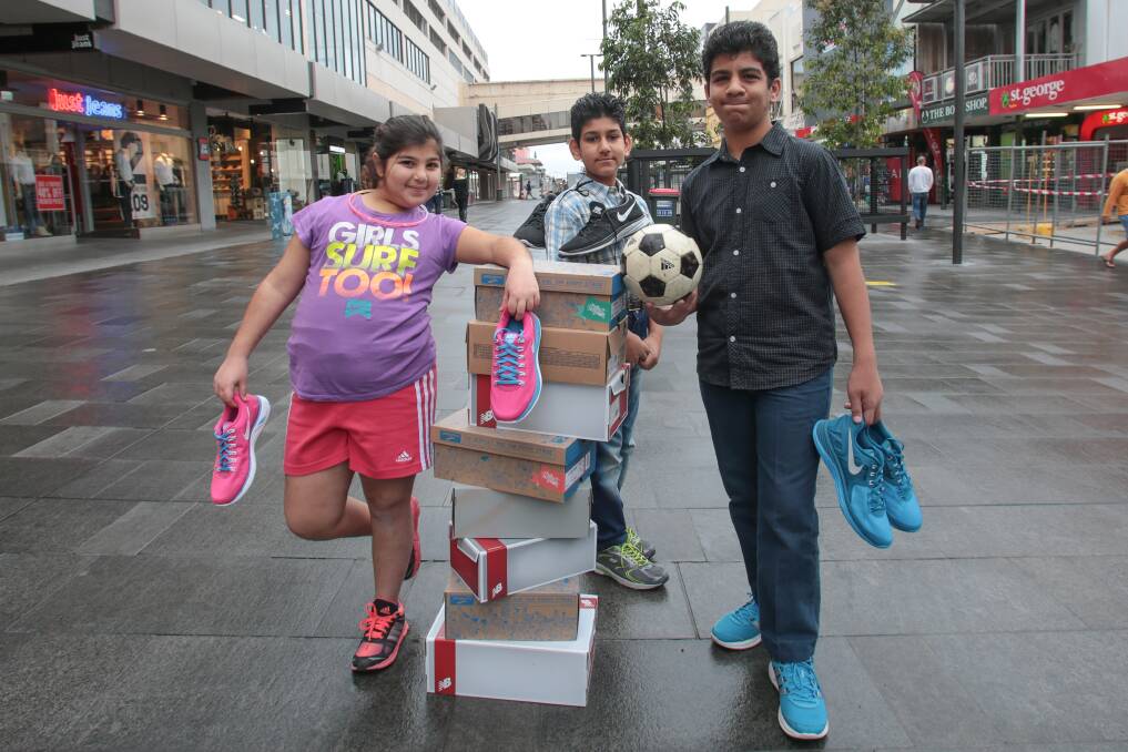 Karrina, 10, Waseem Adil, 12, and Azeez Adil, 14,  with a selection of sneakers. A campaign called Asylum Sneakers has been established to collect sneakers to donate to refugees.  Picture: ADAM McLEAN