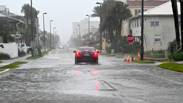 A car makes its way up a flooded 1st Street South in Jacksonville Beach, Florida. Photo: AP
