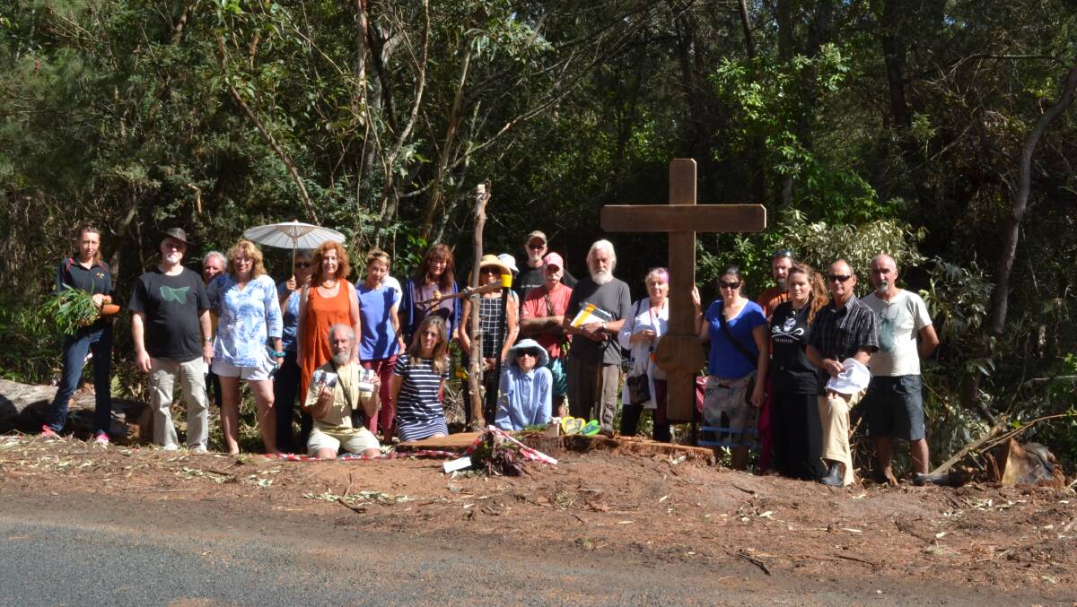 More than 20 people gathered around the site of the once majestic Bum Tree on Tuesday to unveil a wooden cross.