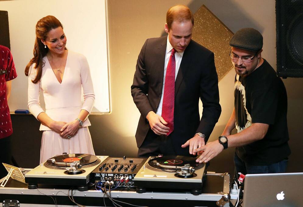 Catherine, Duchess of Cambridge looks on as Prince William, Duke of Cambridge is shown how to play on DJ decks at the youth community centre. Picture: REUTERS