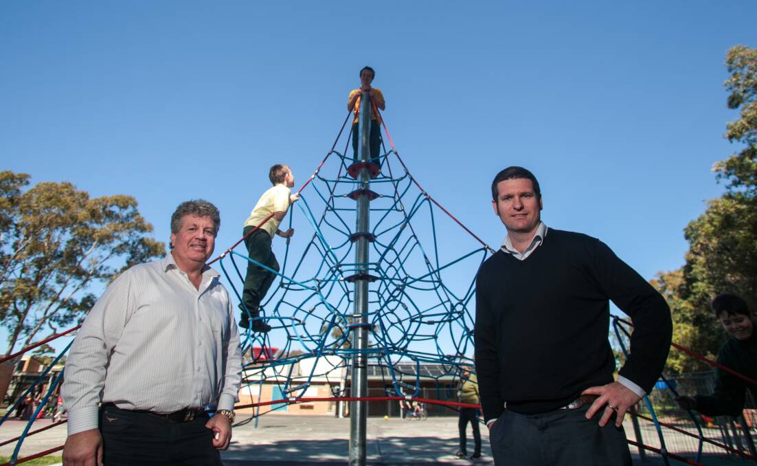 Michael Dennis from the Ocean Beach hotel and Andy Hannelly from Warilla Hotel with Para Meadows students enjoying their new climbing frame. Picture: ADAM McLEAN