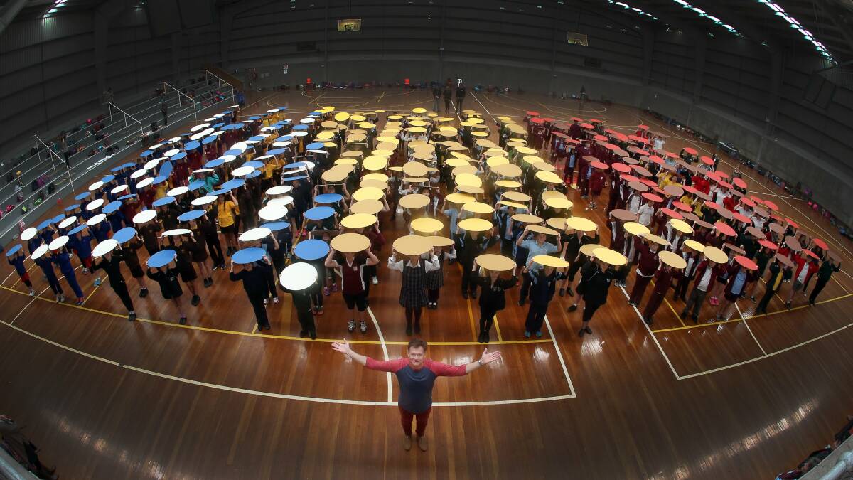 Ian Millard and hundreds of schoolchildren rehearse for the mass Southern Stars 2015 rehearsal. Picture: ROBERT PEET