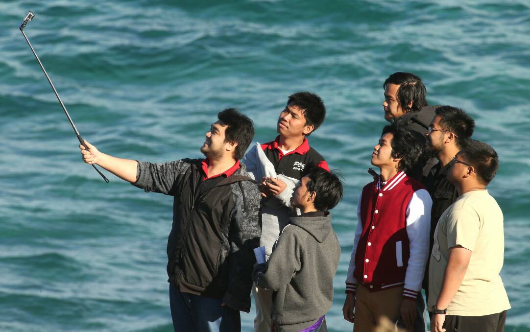 The Selfie Stick is a must for every traveller and tourist. A group is photographed using one at Flagstaff Hill Wollongong. Picture: KIRK GILMOUR