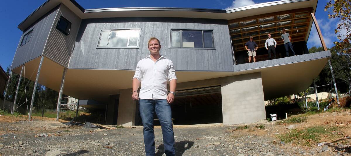 Scott Redwood in front of his net-zero energy and water-efficient house, which his company is designing and constructing. At the rear are tradesmen Matt Alexander, Anthony Mifsud and Joshua Lobb. Picture: KIRK GILMOUR