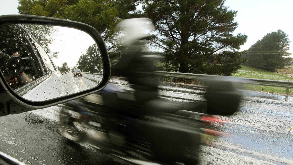 A motorcyclist rides through a hail storm in the Southern Highlands on March 7. Picture: SYLVIA LIBER