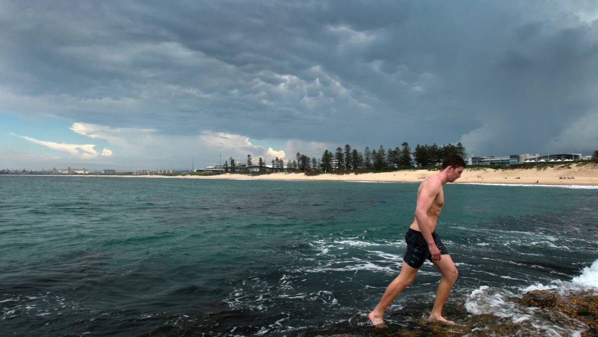 Lachlan Wells leaves Wollongong City Beach as a storm approaches on March 7. Picture: ORLANDO CHIODO