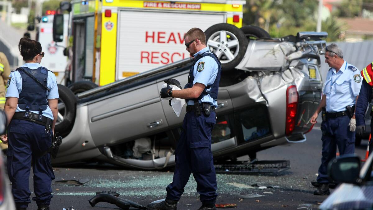Police inspect the car which overturned on Memorial Drive, Woonona. Picture: SYLVIA LIBER