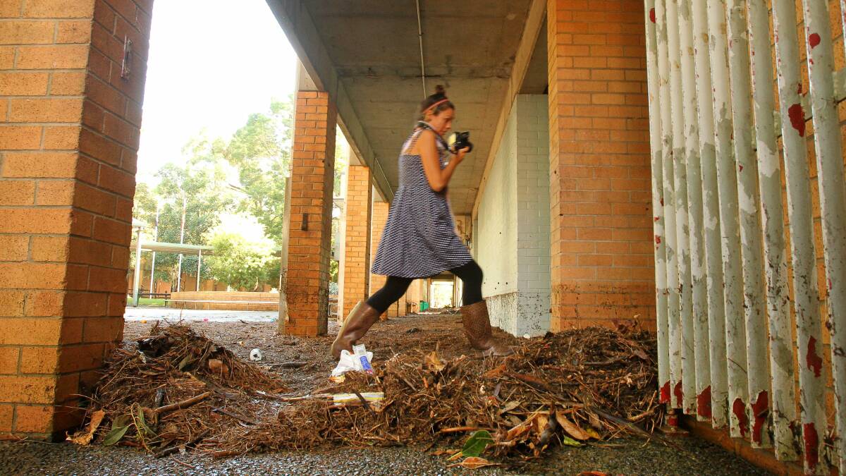 A Bulli High staff member photographs the storm damage on March 25. Picture: KIRK GILMOUR