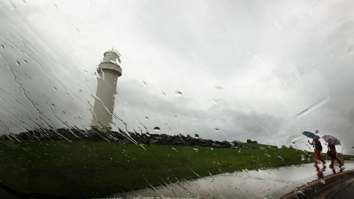 Tourists aren't fazed by the rain at Wollongong Lighthouse on March 24. Picture: SYLVIA LIBER