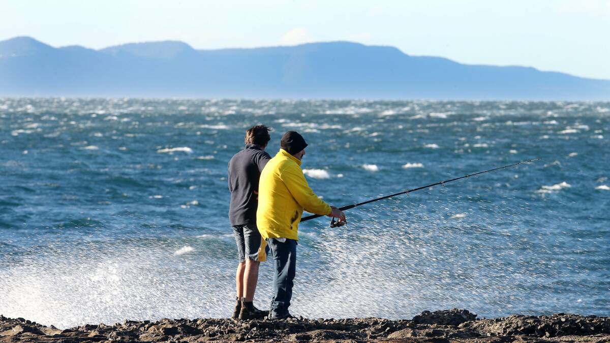 Two rock fisherman brave the windy weather below Flagstaff Point in Wollongong. Picture: KIRK GILMOUR