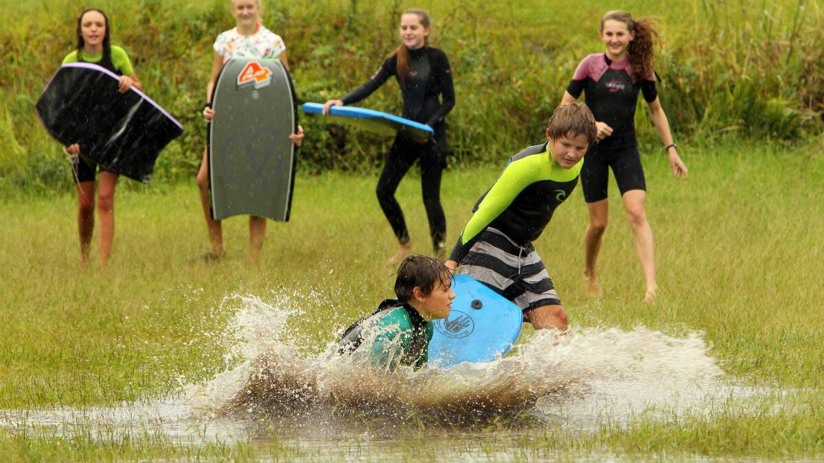 Students from Bulli High School make use of their free time playing in the flooded Bulli Park on March 27. Picture: KIRK GILMOUR