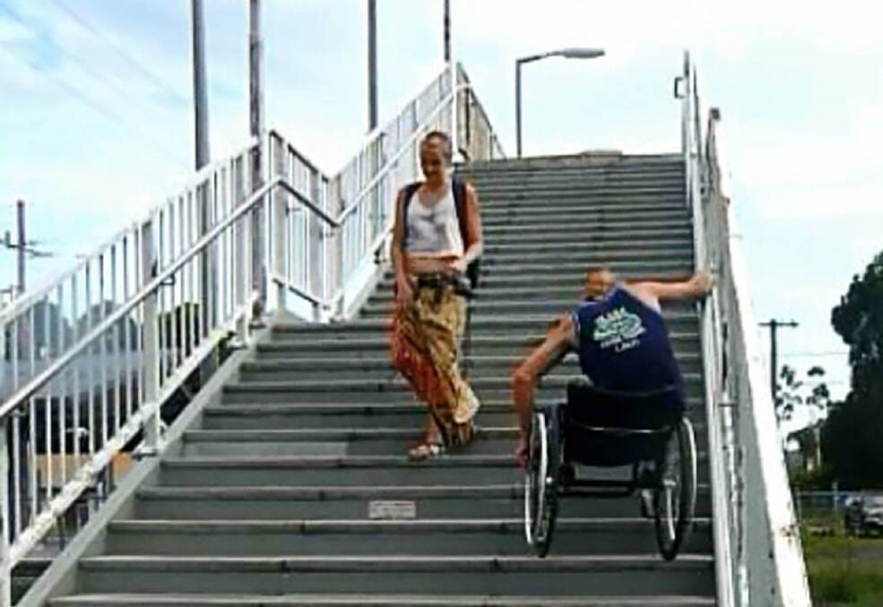 A wheelchair-bound man struggles down the stairs in the video.