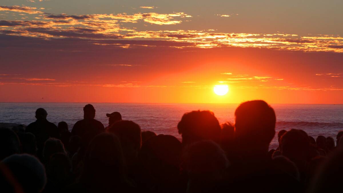 Sunrise at Austinmer Beach during Saturday's Anzac Day Dawn Service. Picture: KIRK GILMOUR