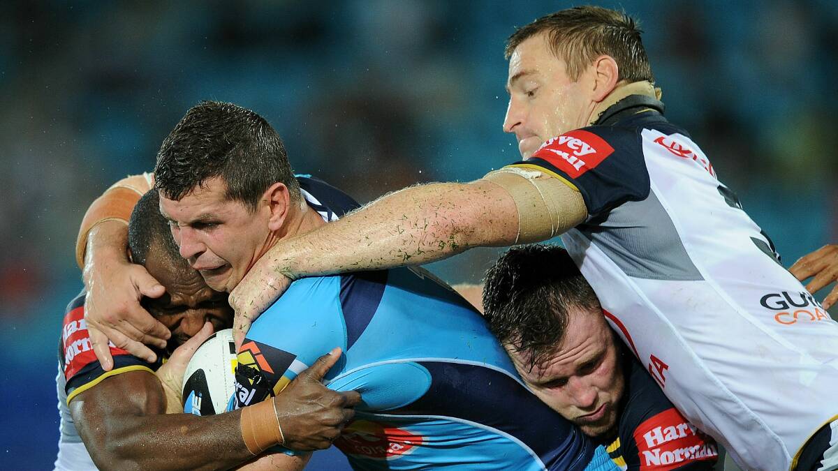 Gold Coast's Greg Bird is group-tackled by North Queensland players in Monday night's match at Robina Stadium. Picture: GETTY IMAGES
 