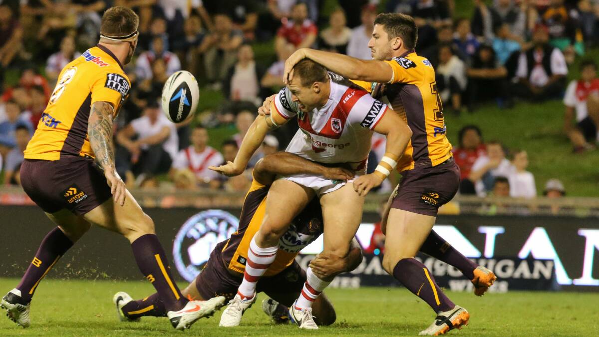 St George Illawarra's Trent Merrin offloads as he is tackled by the Brisbane defence at WIN Stadium on Friday night. Picture: ROBERT PEET