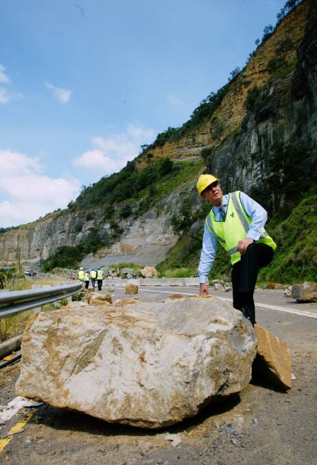 Roads and Traffic Authority chief executive Paul Forward inspects a large rock-fall on Lawrence Hargrave Dr, north of Wollongong. The largest rock weighed about 30 tonnes.