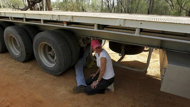 Coonamble farmer Ted Borowski locks himself onto the axle of a heavy articulated vehicle, bringing a Santos convoy to a standstill in the Pilliga State Forest. Picture: DEAN SEWELL