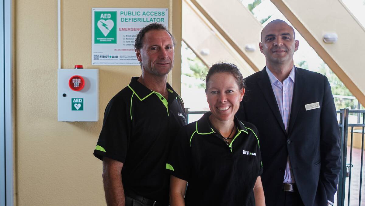 Mark and Rebecca McCarthy from Wollongong First Aid, and Novotel General Manager Steve Savic with a newly installed automated external defibrillator. Picture: CHRISTOPHER CHAN