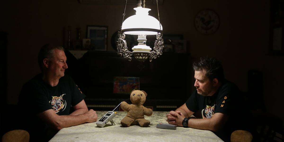 Paranormal investigators Steve Lynch and Dan McMath use a child’s toy to encourage spirits. Picture: CHRISTOPHER CHAN
