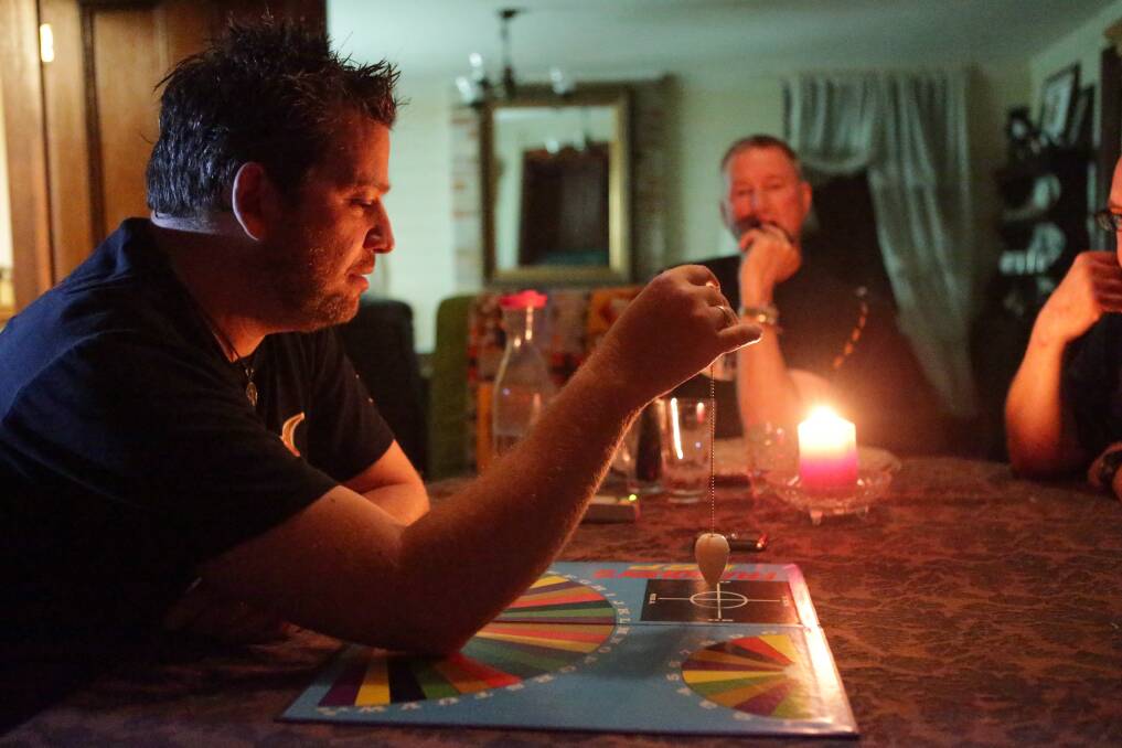 Paranormal investigator Dan McMath uses a pendulum board to communicate with spirits. Picture: CHRISTOPHER CHAN