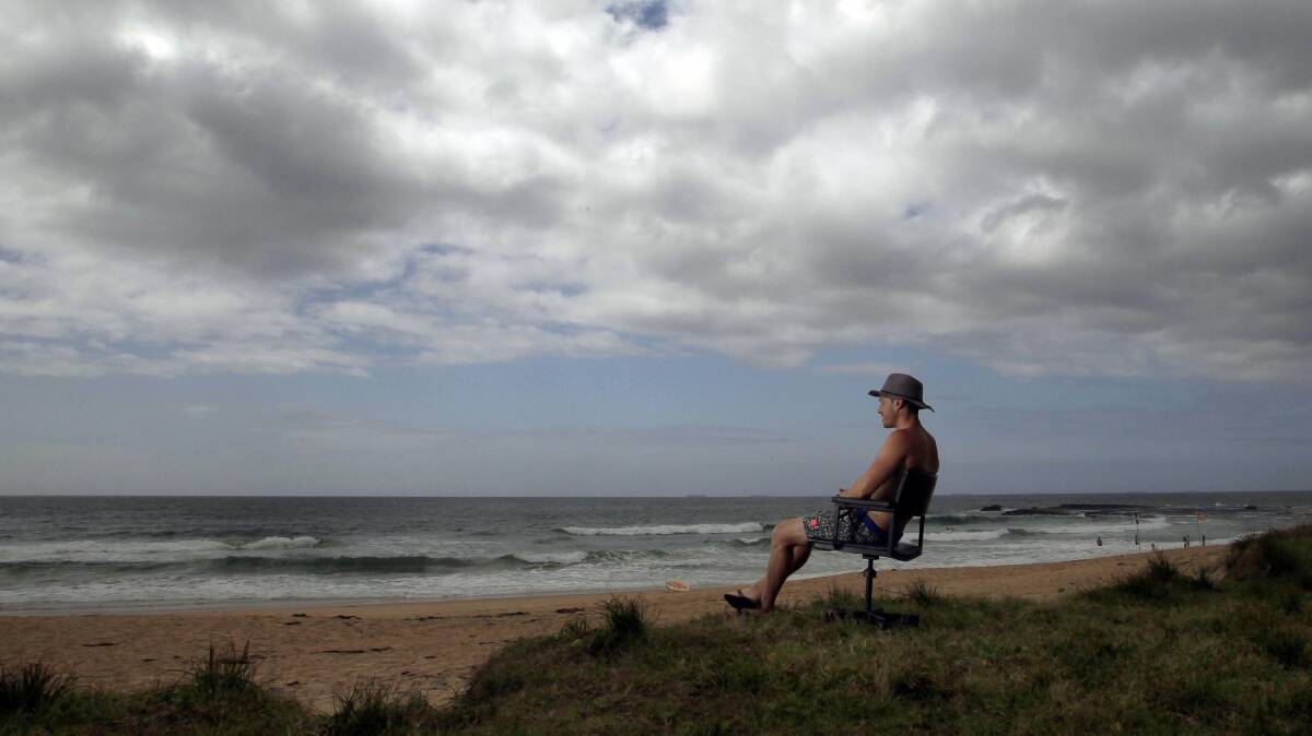 Towradgi man Lee Sullivan takes advantage of a discarded office chair on Coledale Beach. Picture: ANDY ZAKELI