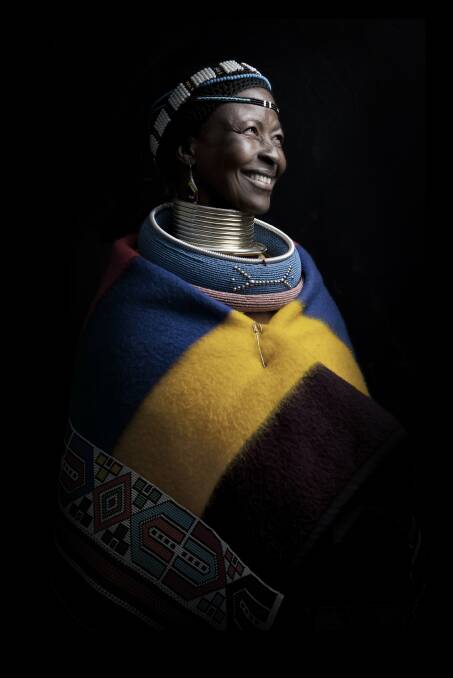 NDEBELE SMILE. Pilgrims Rest, South Africa. I had stopped for supplies in Pilgrims Rest in South Africa whilst en route to Botwana. As I stopped I saw two Ndebele women sitting in front of a shop waiting for a lift. As I entered the store they asked me if I was heading north and if so could I give them a lift. As I was heading in that direction I could give them a lift. As the women heard this news a huge smile broke out across one woman's face. Immediately I wanted to take her picture. I quickly set up my equipment around the side of the store and organised an impromptu shoot in favour for the lift back to their colourful village.
