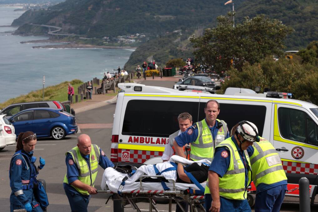 A woman is transported to the waiting NSW Ambulance helicopter at Bald Hill in Stanwell Park. Picture: ADAM McLEAN
