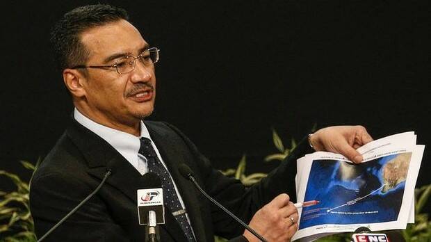 Malaysia's acting Transport Minister Hishammuddin Hussein holds satellite images as he speaks about the search for MH370. Picture: REUTERS