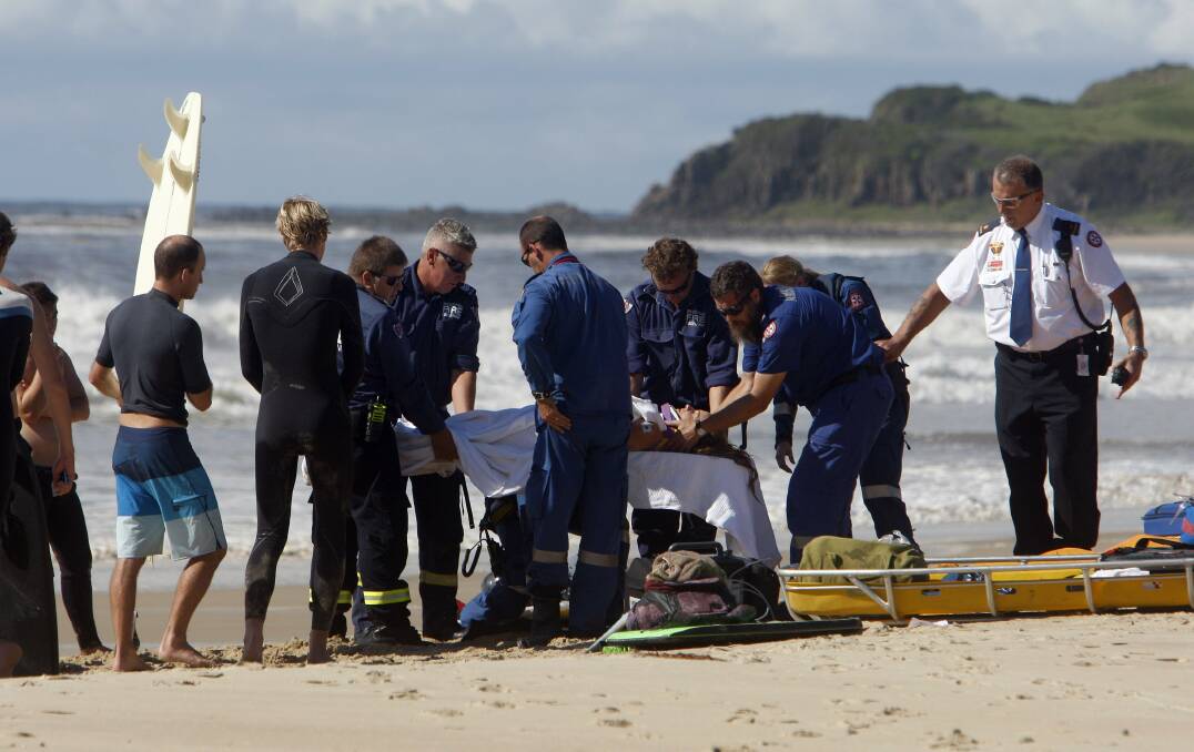 Ambulance paramedics treating the surfer injured at Mystics Beach this morning. Picture: ANDY ZAKELI